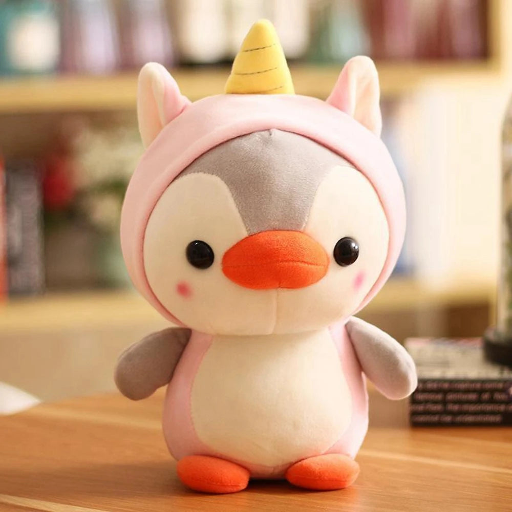 Cute plush penguin dressed as a unicorn, stands on a wooden bench.
