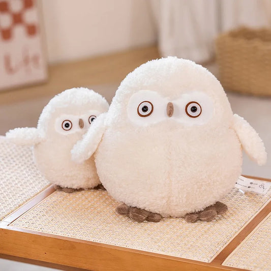 Two soft plush owl toys in different sizes, made of white soft material, displayed on a wooden surface.