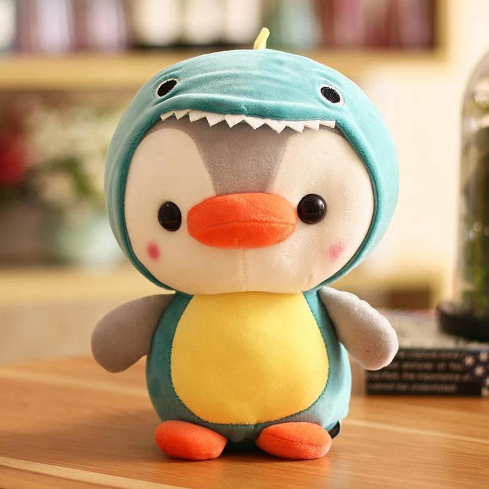 Cute plush toy penguin dressed in a shark costume, sitting on a wooden surface.