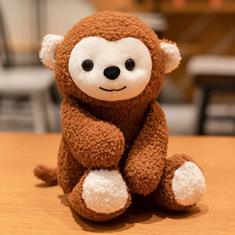Cute monkey plush toy sits upright on a wooden bench