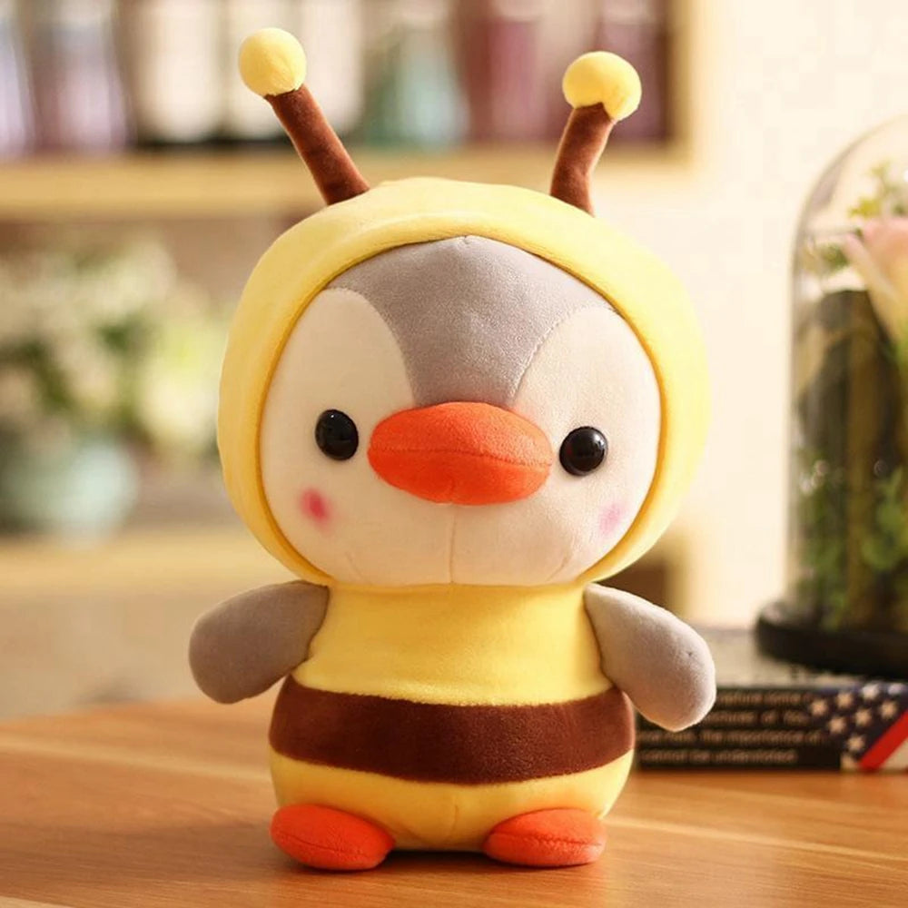 Cute penguin plush toy dressed in a bee costume stands on a wooden bench.