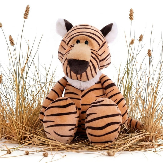 A plush tiger toy sitting upright among dried grass stems on a white background.