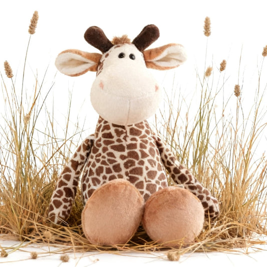 A plush giraffe toy sitting in a small arrangement of dried grass on a white background.